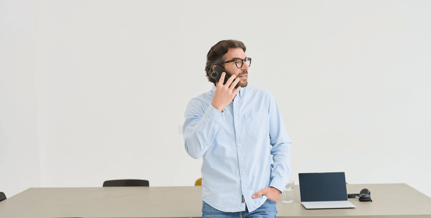 Der Gründer und Chef von loyos bi, Martin Sperling, steht angelehnt an einen Tisch, telefoniert, schaut zur Seite.