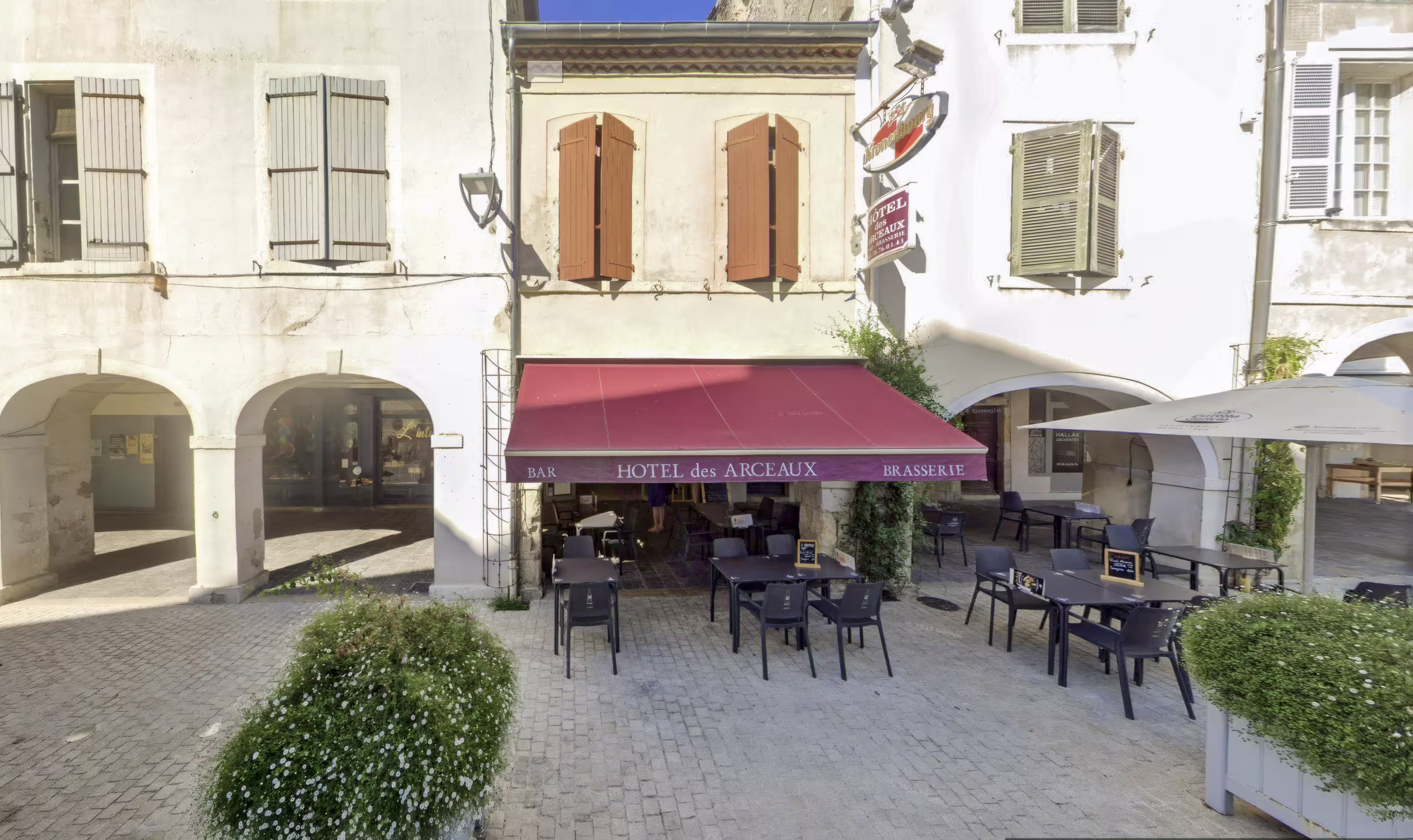 Façade en briques du Bistrot des Arceaux face à l’abbatiale de Saint-Sever, terrasse calme baignée de lumière du matin.