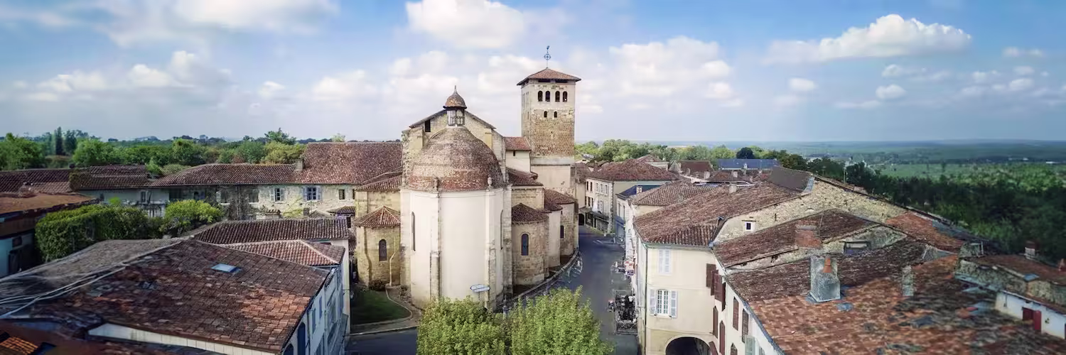 Vue aérienne du centre historique de Saint-Sever avec l’abbatiale et les toits en tuiles rouges dominant la campagne landaise.