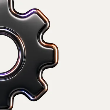 Close-up of a shiny black gear on a light background, showing half of the gear's teeth.