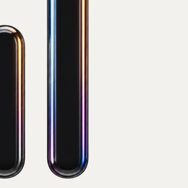 Close-up of two shiny vertical black capsules with reflective metallic edges on a white background.