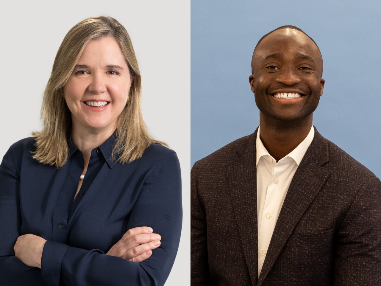 Smiling middle-aged woman with blonde hair in a navy blue shirt stands with arms crossed next to a smiling black man in a dark suit and white shirt against a blue background.