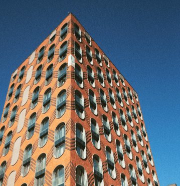Unique architectural design featuring a grid of oval windows on a vibrant orange building exterior.
