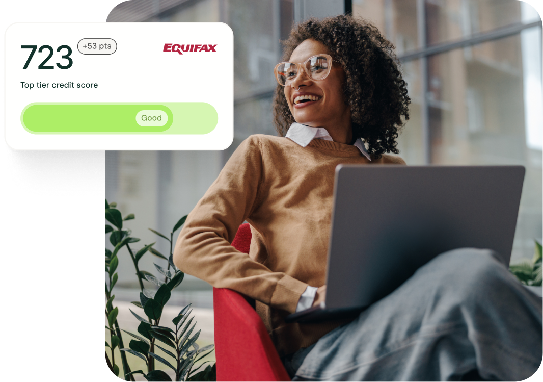 A happy professional woman working sitting with her laptop with a credit score of 802 rated as excellent displayed