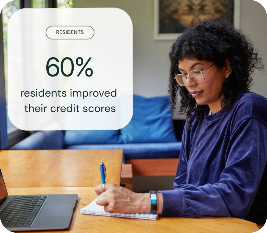 A happy professional woman working sitting with her laptop with a credit score of 802 rated as excellent displayed 
