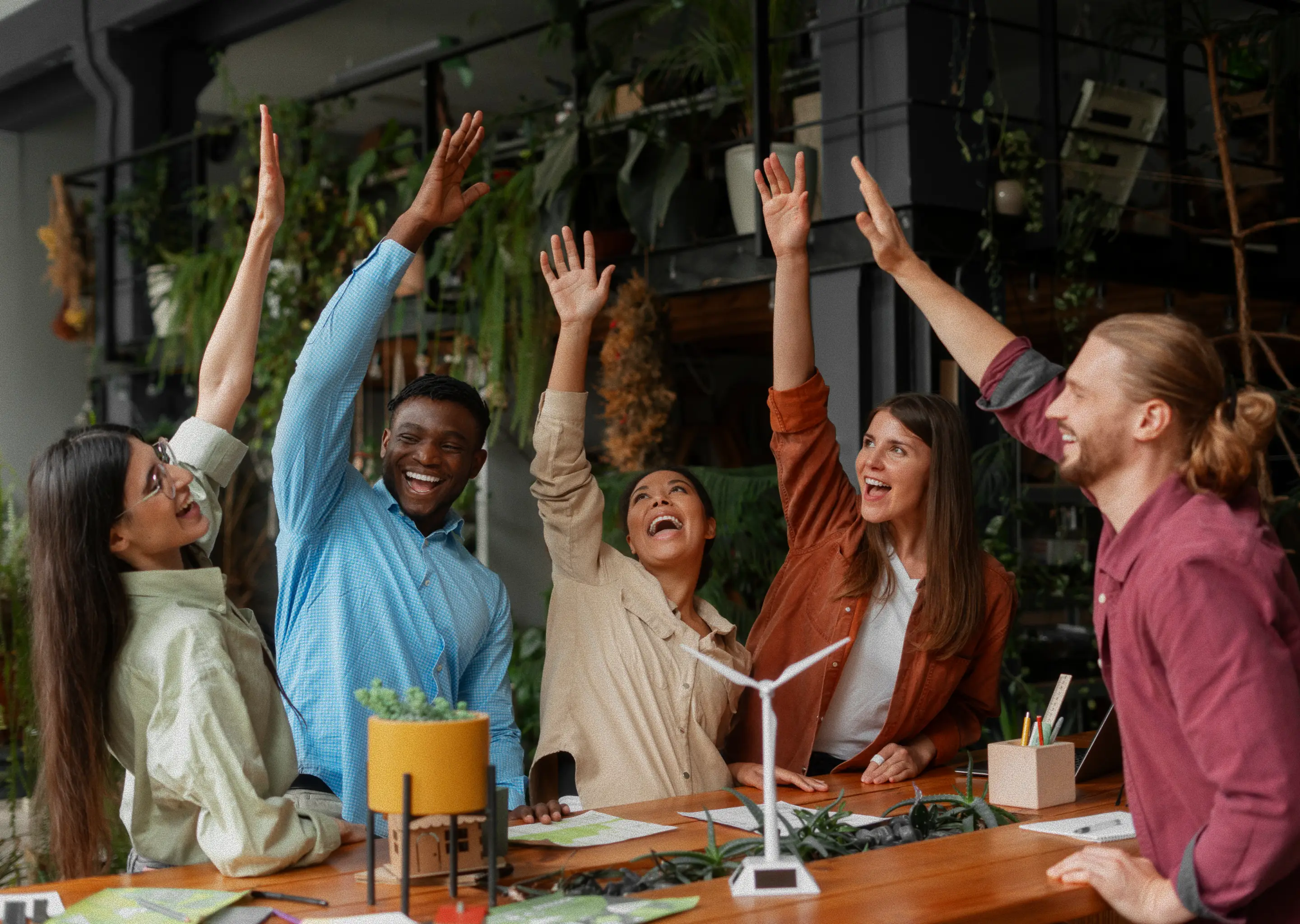 Group of students raising their hands in celebration of teamwork and shared achievement.