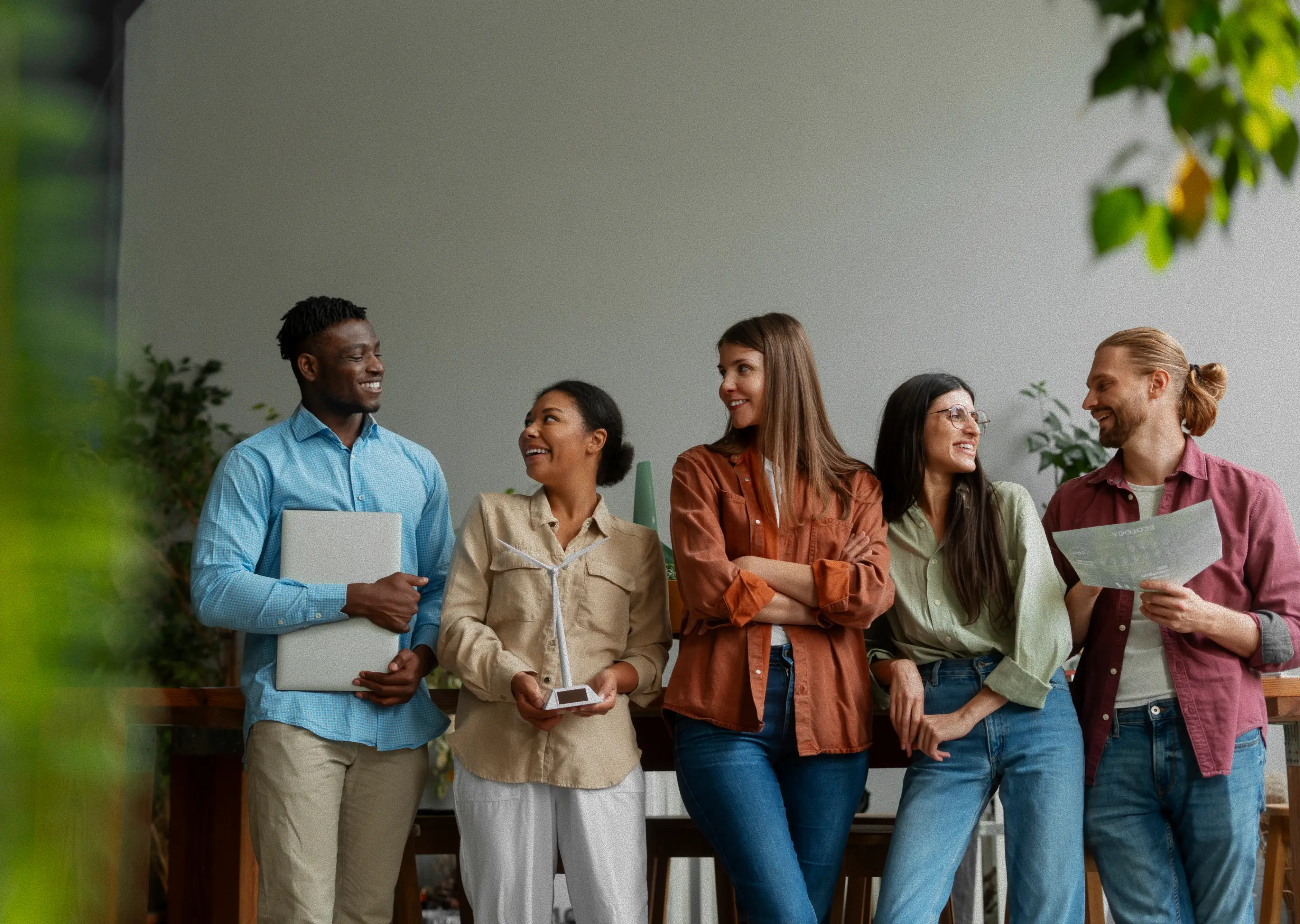 Five students standing together, smiling and talking after a group project session.