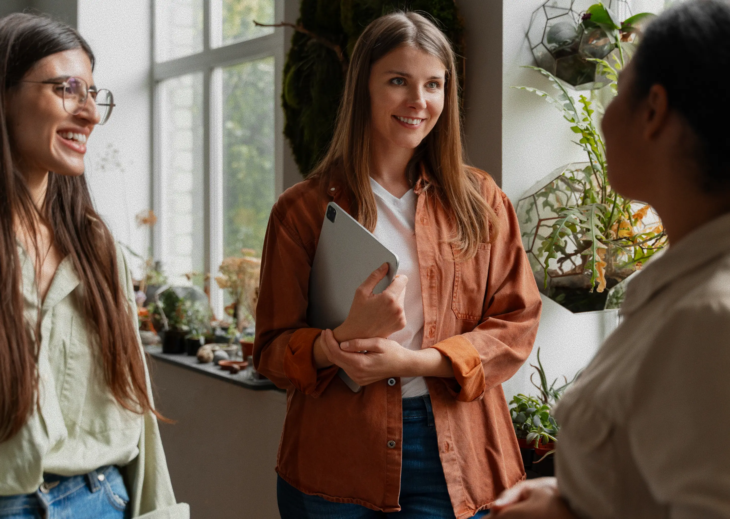 Three students smiling and talking together during a break in class.