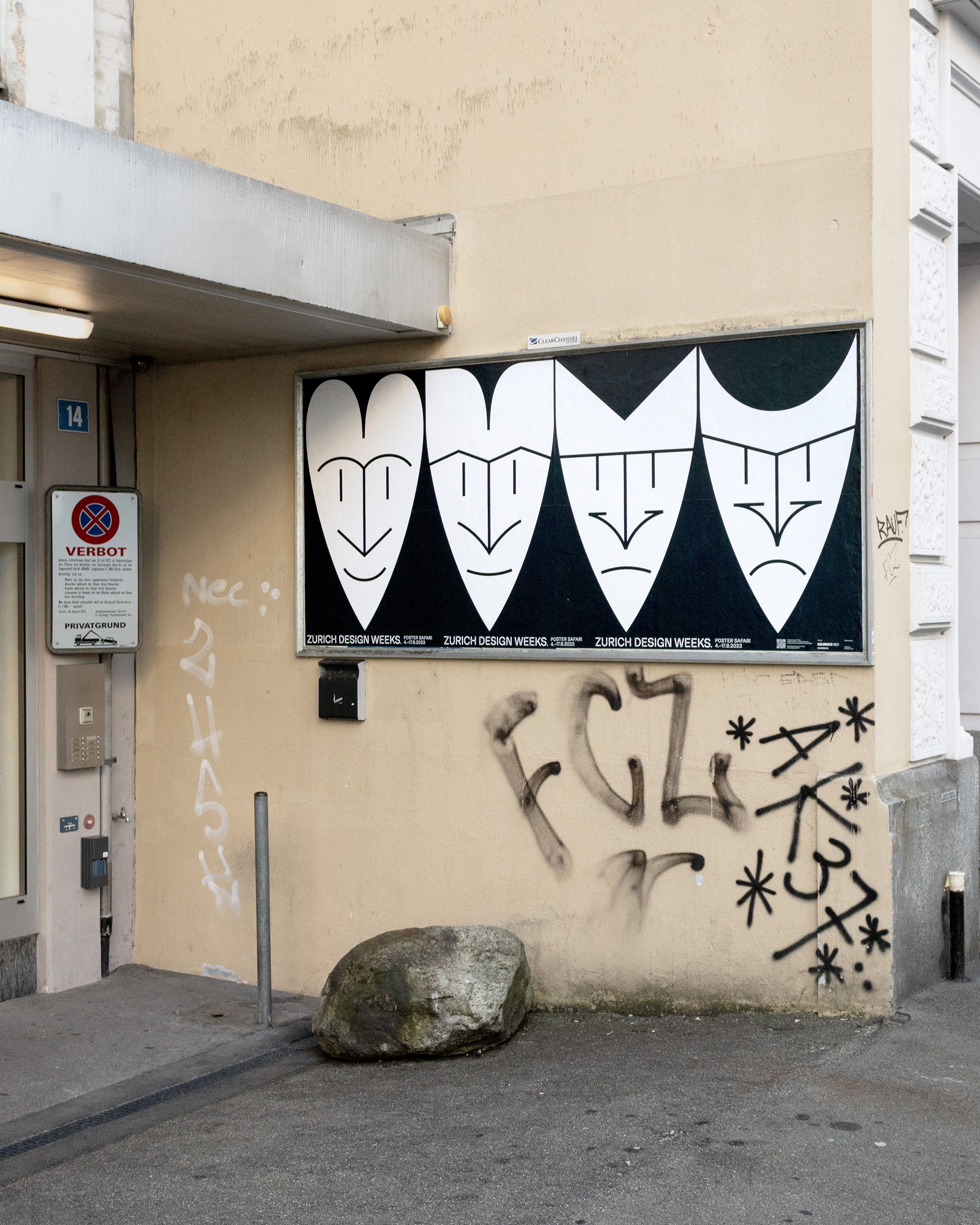 F12 Poster of four faces turning from love to hate in black and white hanging on a wall on the streets of zurich