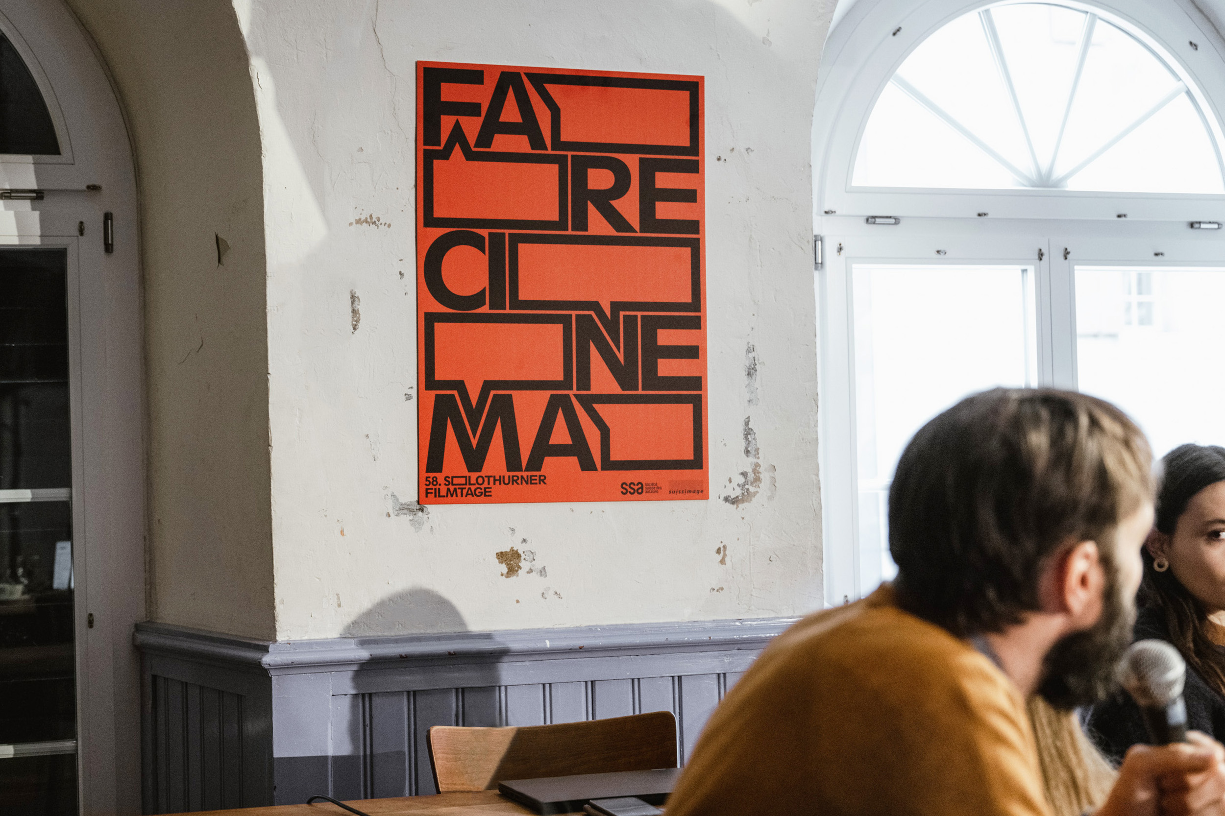 The red "Fare Cinema" visual with black typography on a white wall