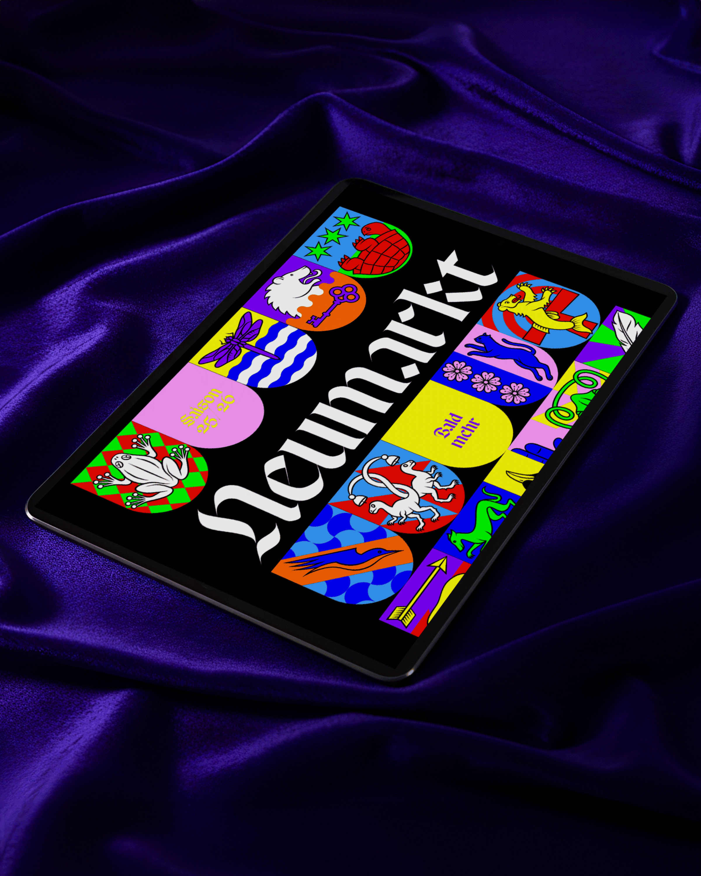 Tablet displaying colorful heraldic shields and the word 'Neumarkt' on a purple satin fabric background.