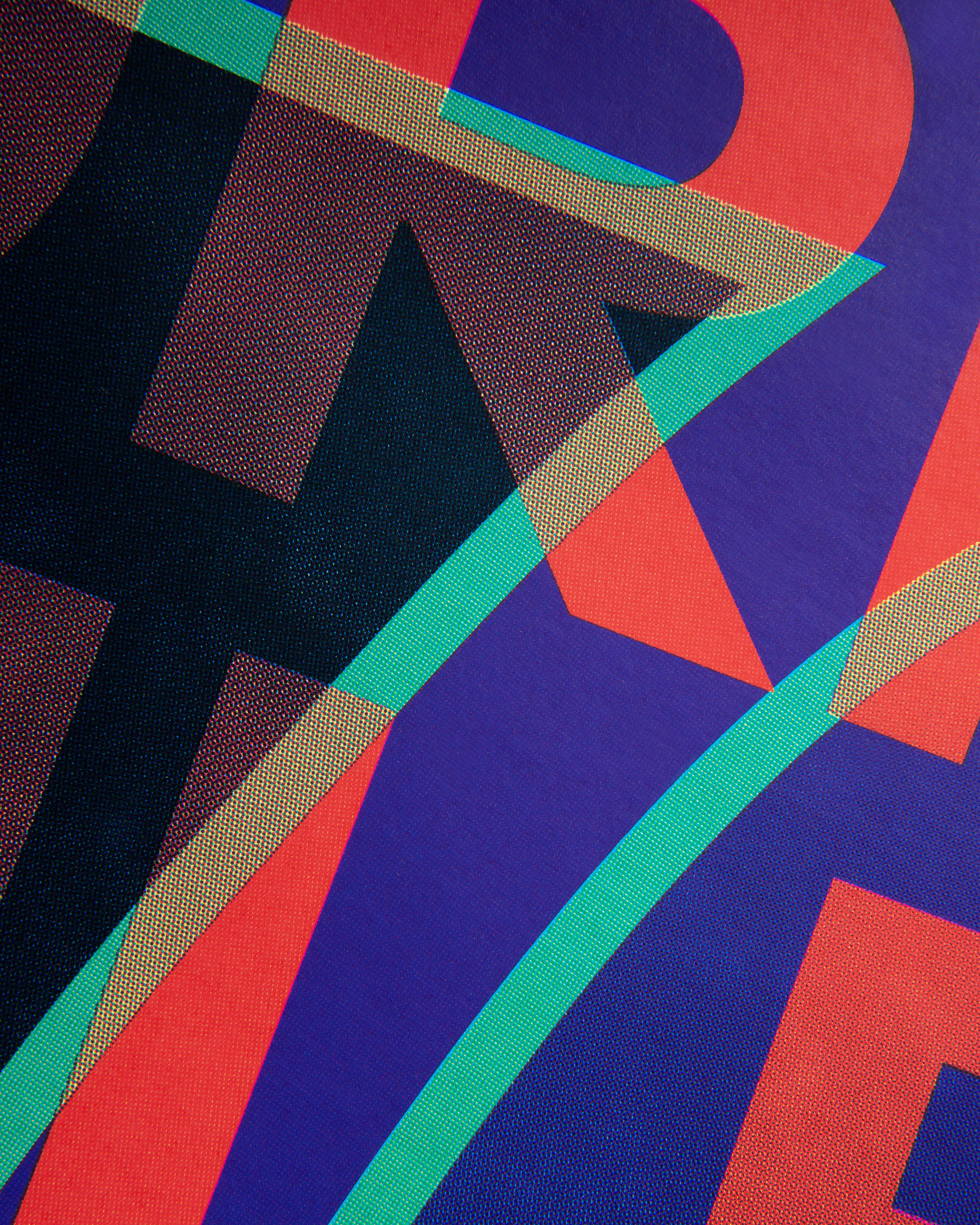 Close-up of layered colored dots forming abstract overlapping shapes in red, purple, teal, and black.