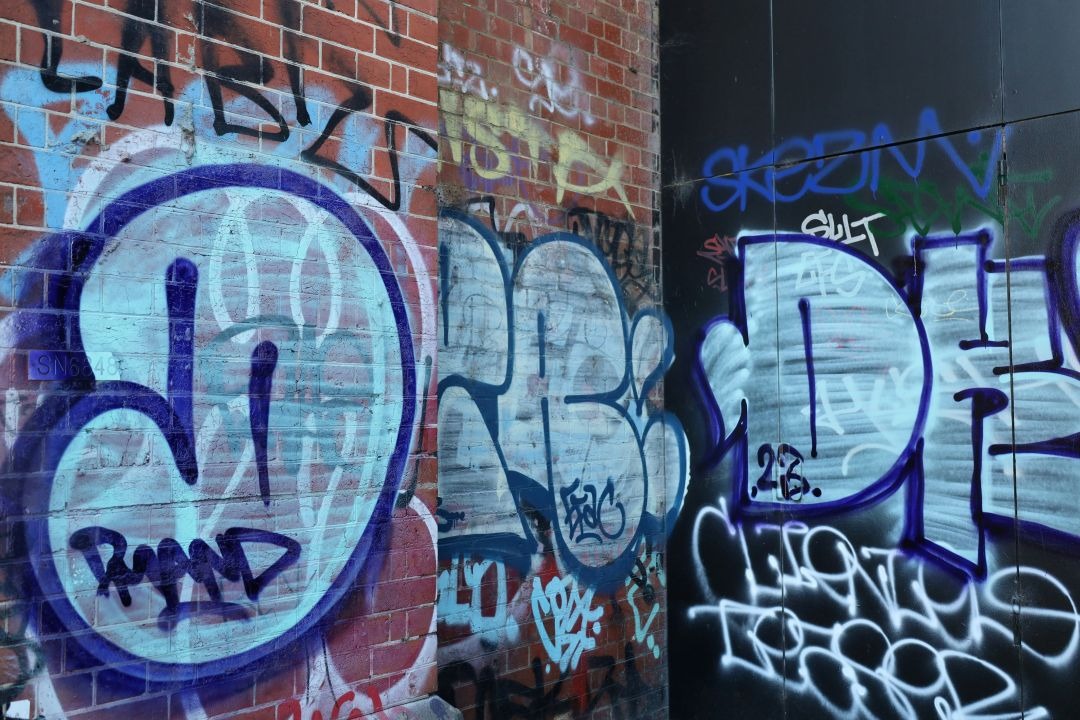 Sehr viel Graffiti an einer Wand as jetzt dan gereinigt wird.