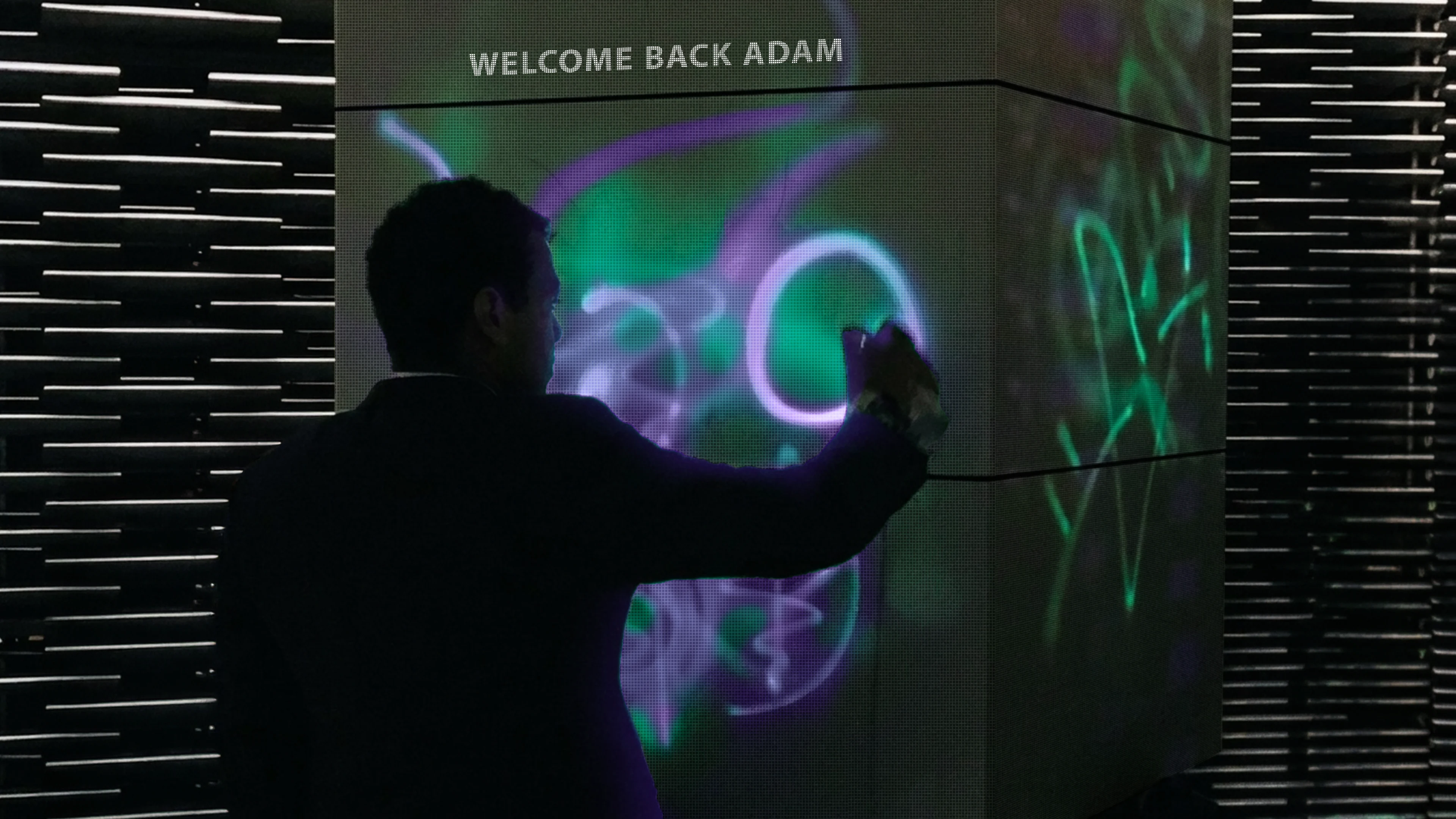 Man interacting with a responsive digital pillar displaying a personalised “Welcome back Adam” message