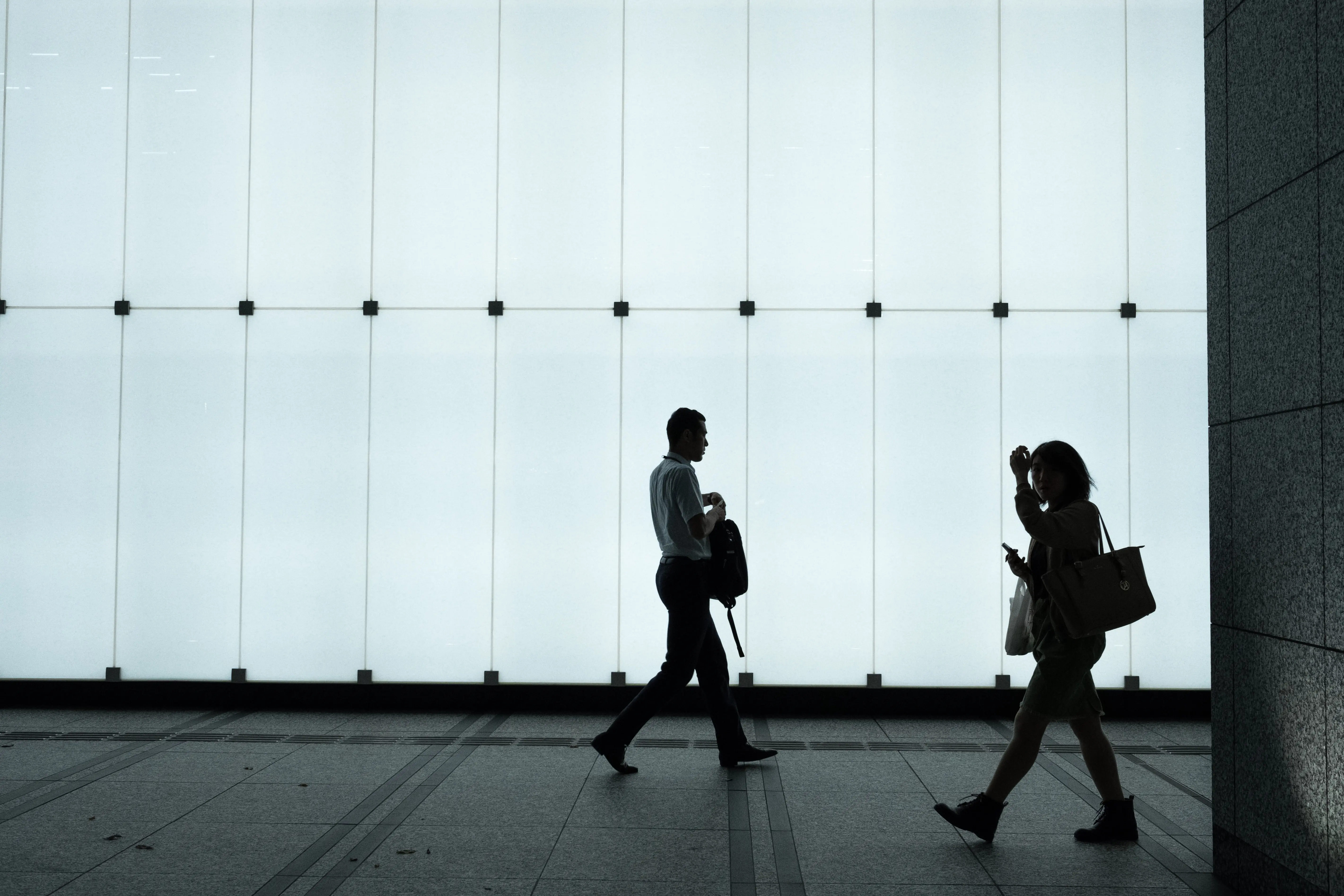 Silhouettes of two people inside a contemporary interior, exploring human experience and space.