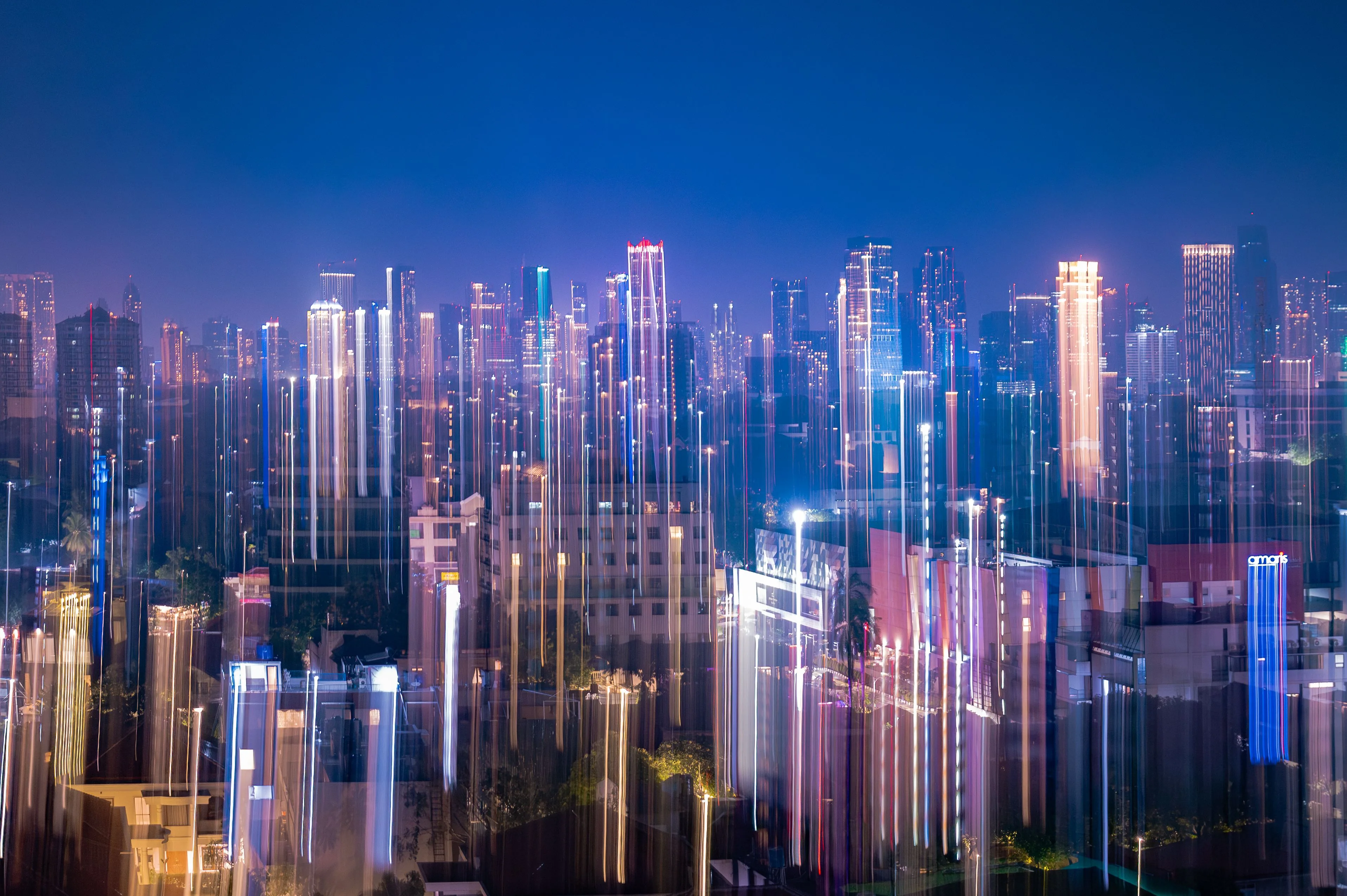 A dynamic capture of Jakarta's skyline at night with vibrant neon light streaks and city lights.