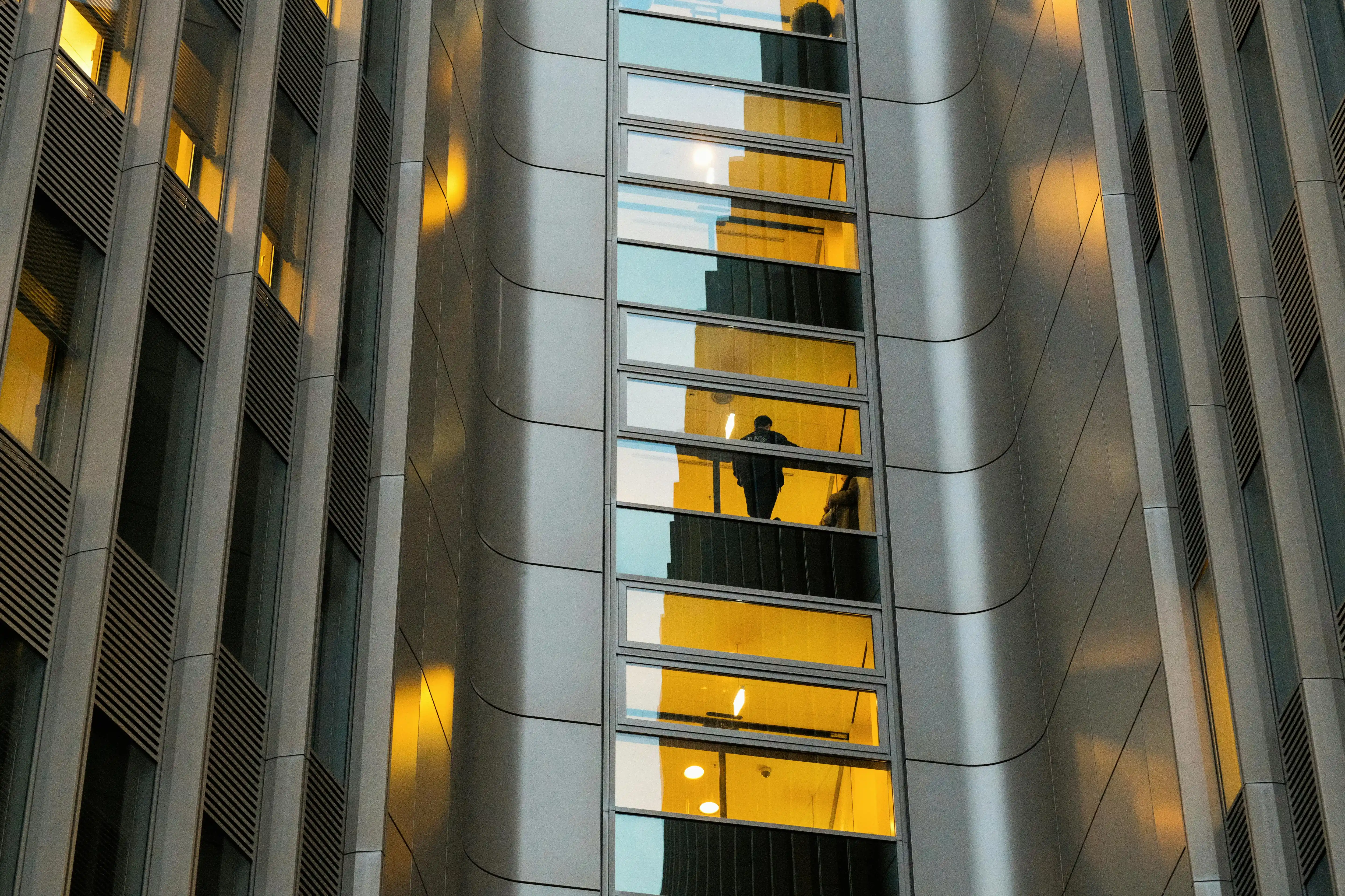 Person viewed through a window within a contemporary building