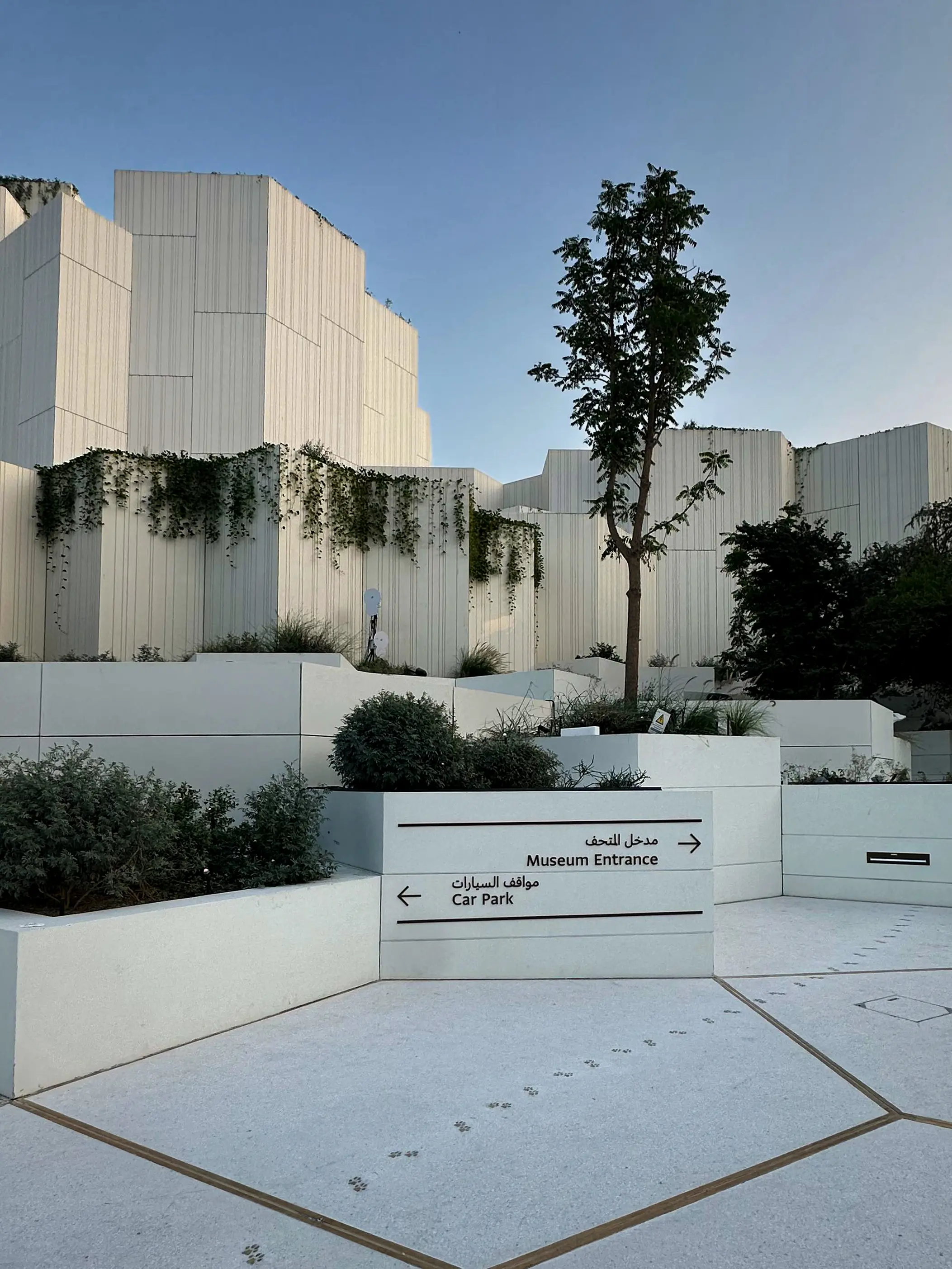 Wall-mounted directional wayfinding signage at the Natural History Museum Abu Dhabi.