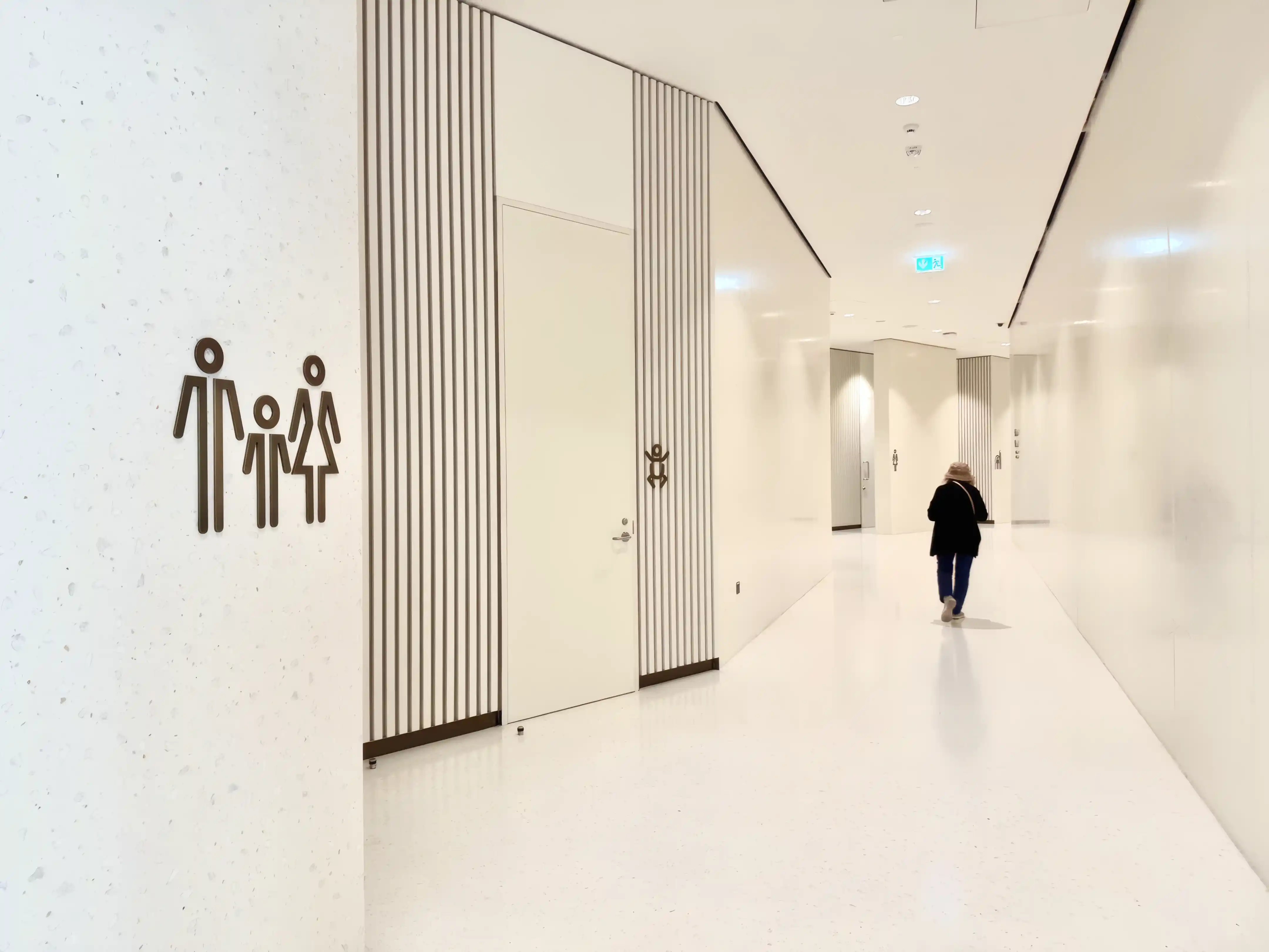 Amenity identification signage along a corridor at the Natural History Museum Abu Dhabi, helping visitors locate facilities.