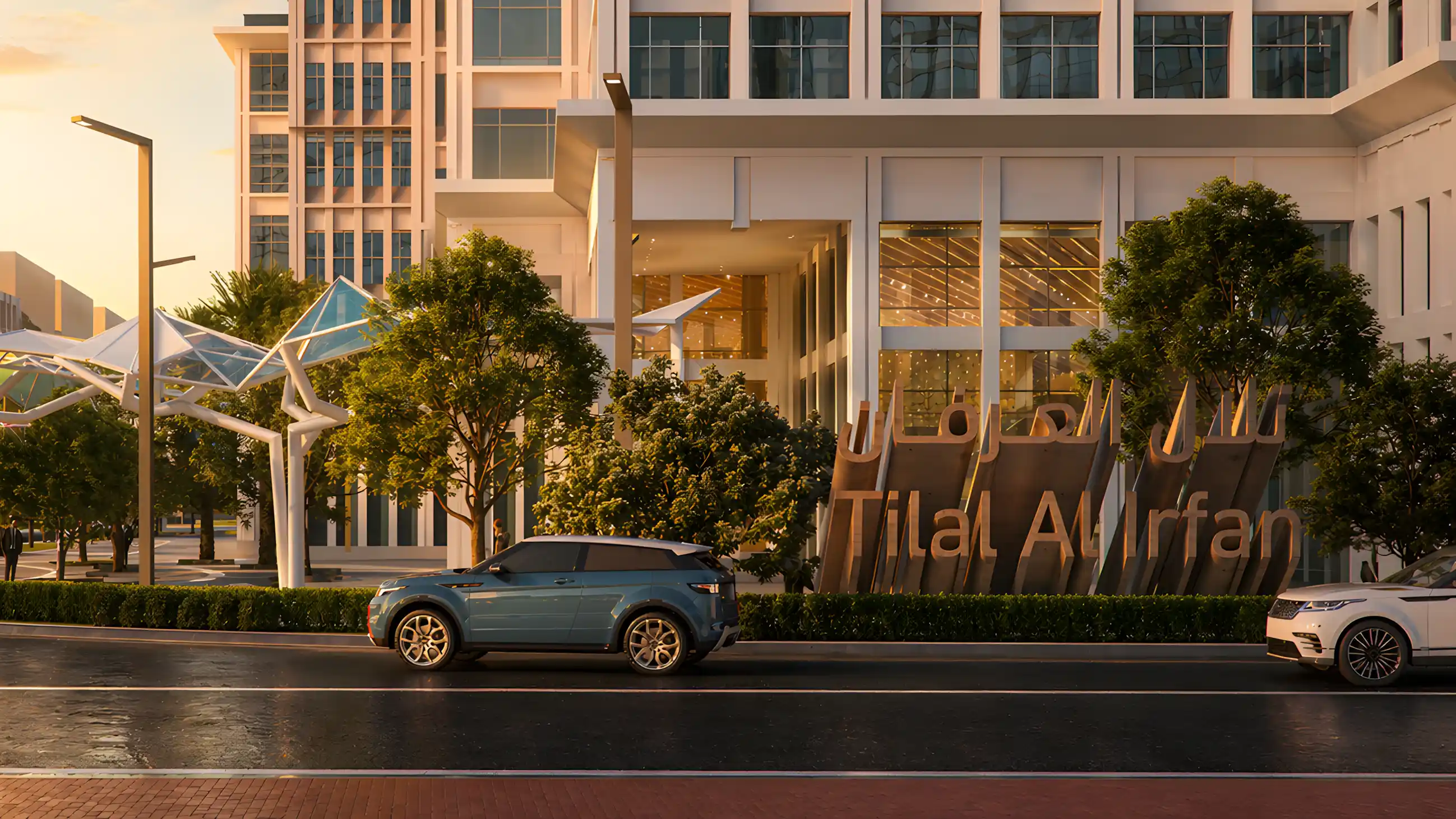 Vehicles passing branded gateway signage at Tilal Al Irfan, reinforcing the destination's place identity.