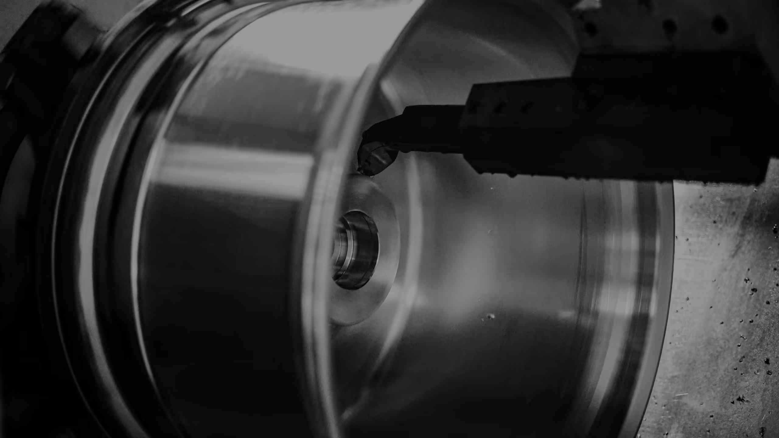 Close-up of a CNC lathe machine cutting a metal cylindrical part.