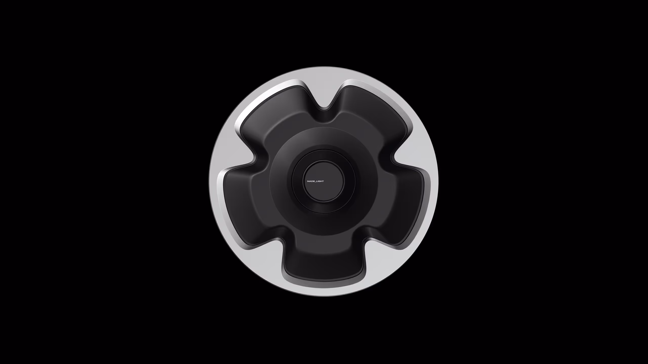 Top view of a circular black and silver modern object with the word MADE_LIGHT in the center.
