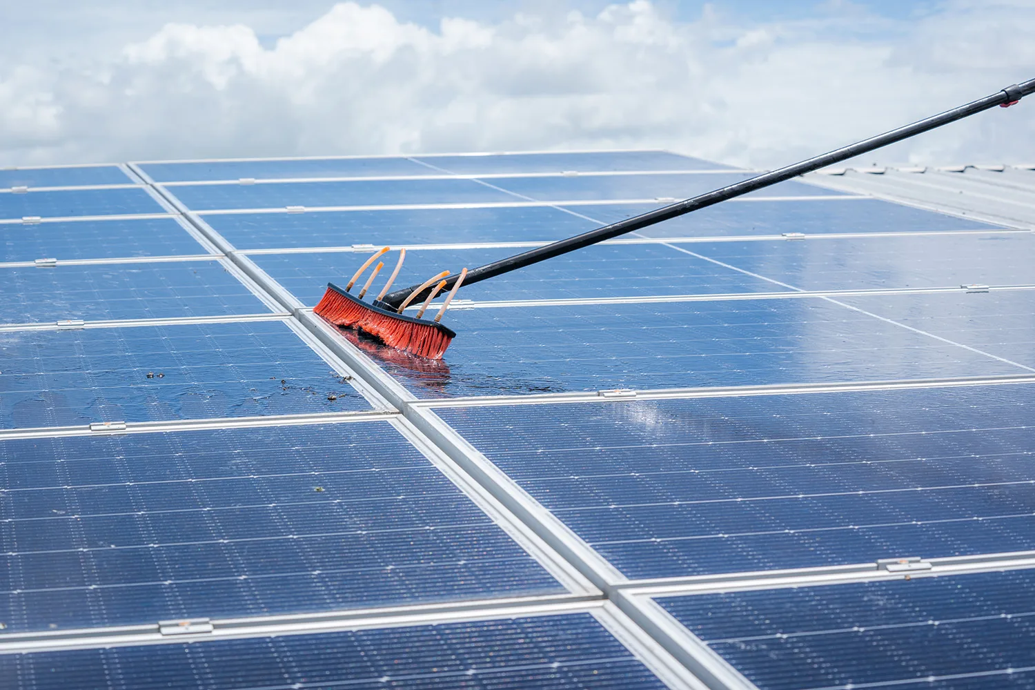 Medewerker van Diamond Cleaning Belgium poetst zonnepanelen met borstel voor optimaal rendement