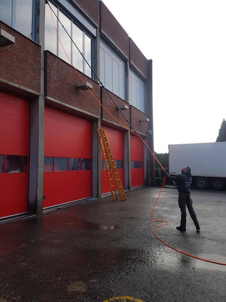 Industriële hal met rode poorten gereinigd door professionele ramenwassers