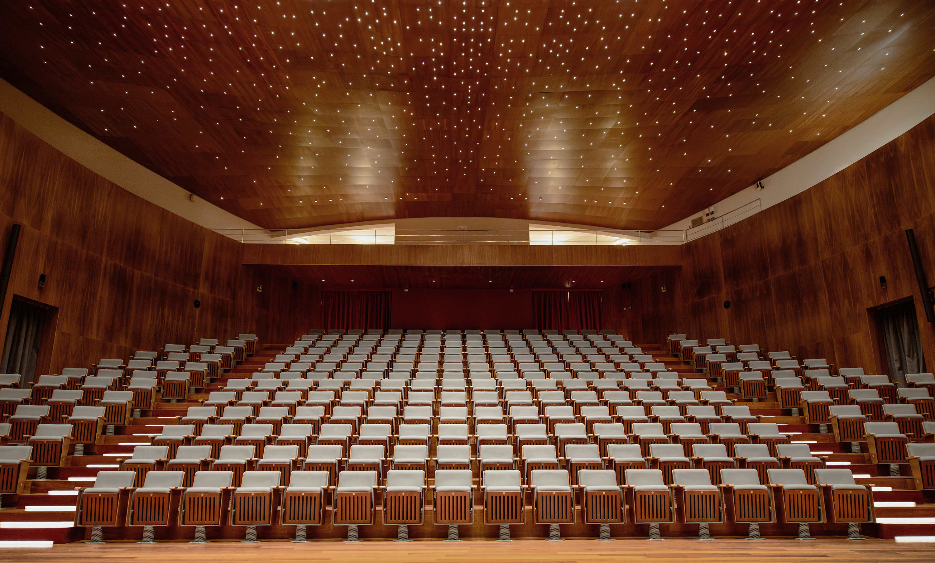 Wood-paneled ceiling with numerous small recessed lights creating a sparkling star-like pattern.