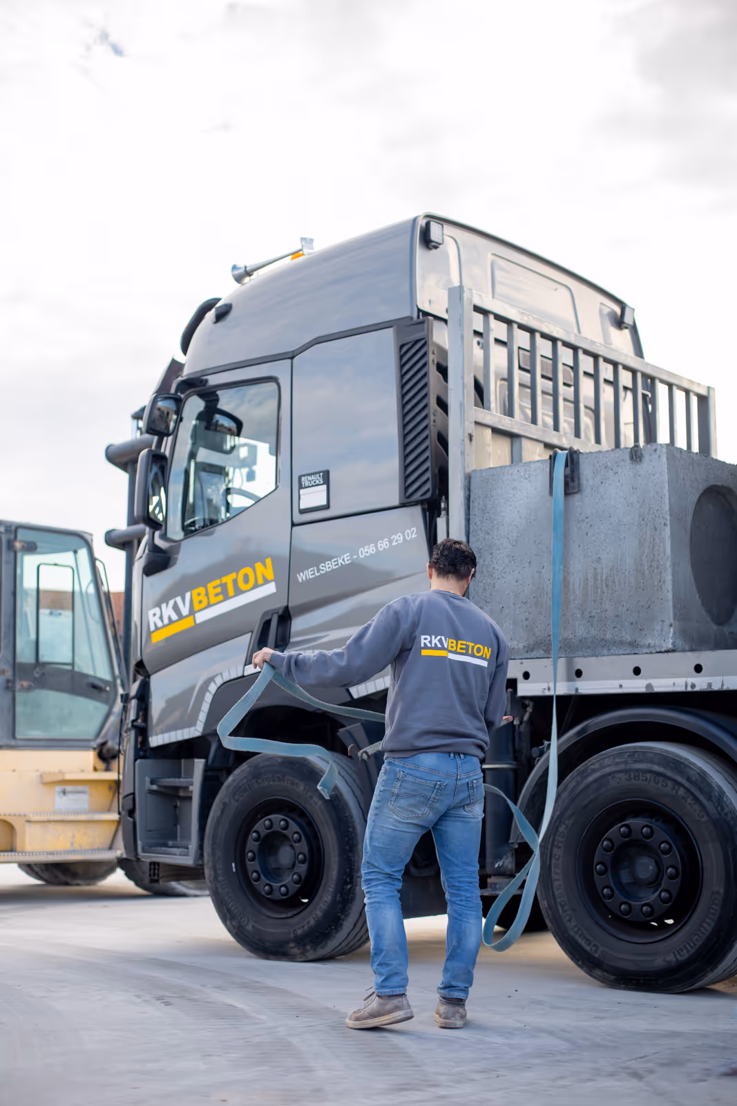 Zijaanzicht van vrachtwagen van RKV Beton, klaar voor transport van betonproducten