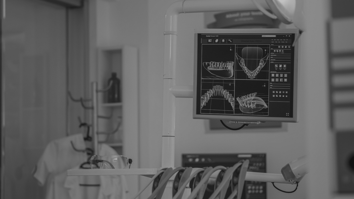 Ett besöksrum hos tandläkaren med skärmar som visar röntgenplåtar. 