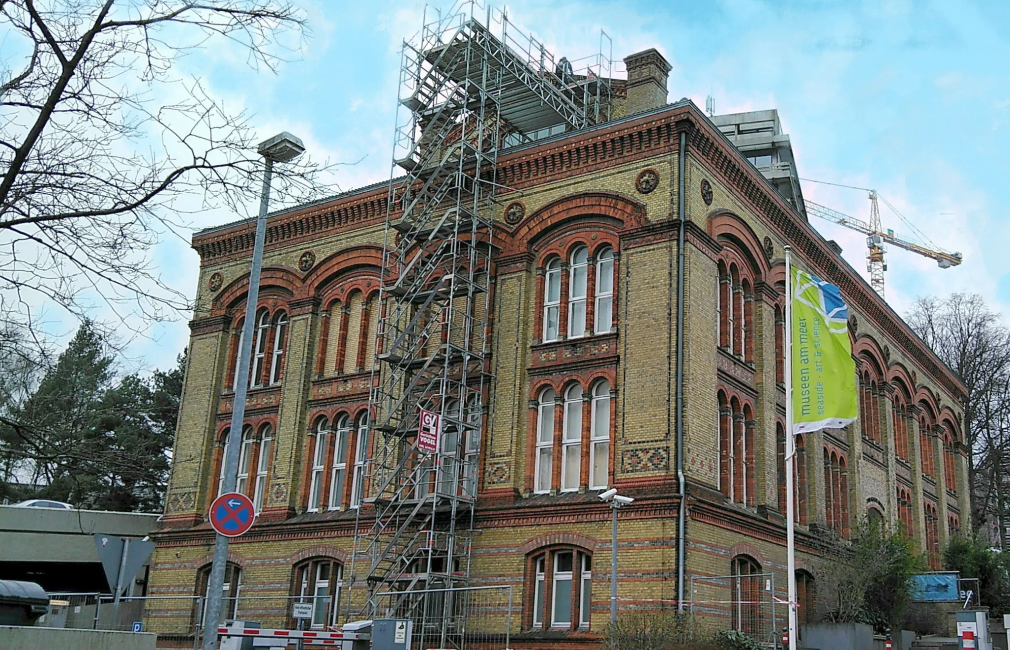 Historisches Backsteingebäude mit Gerüst an der Front und Flagge mit der Aufschrift Museen am Meer.