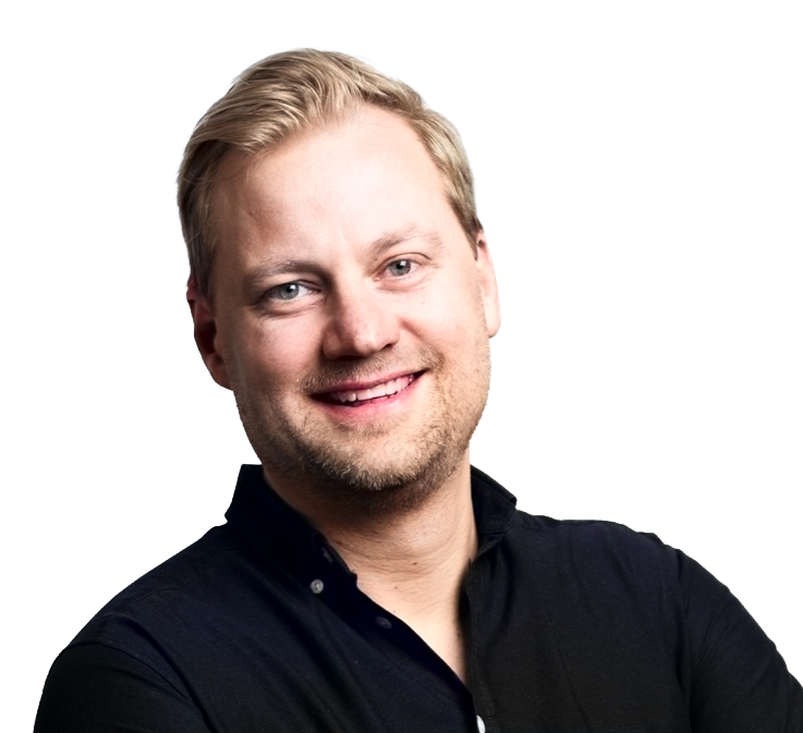 Smilende mann med lyst hår og blå øyne iført mørk skjorte mot hvit bakgrunn.