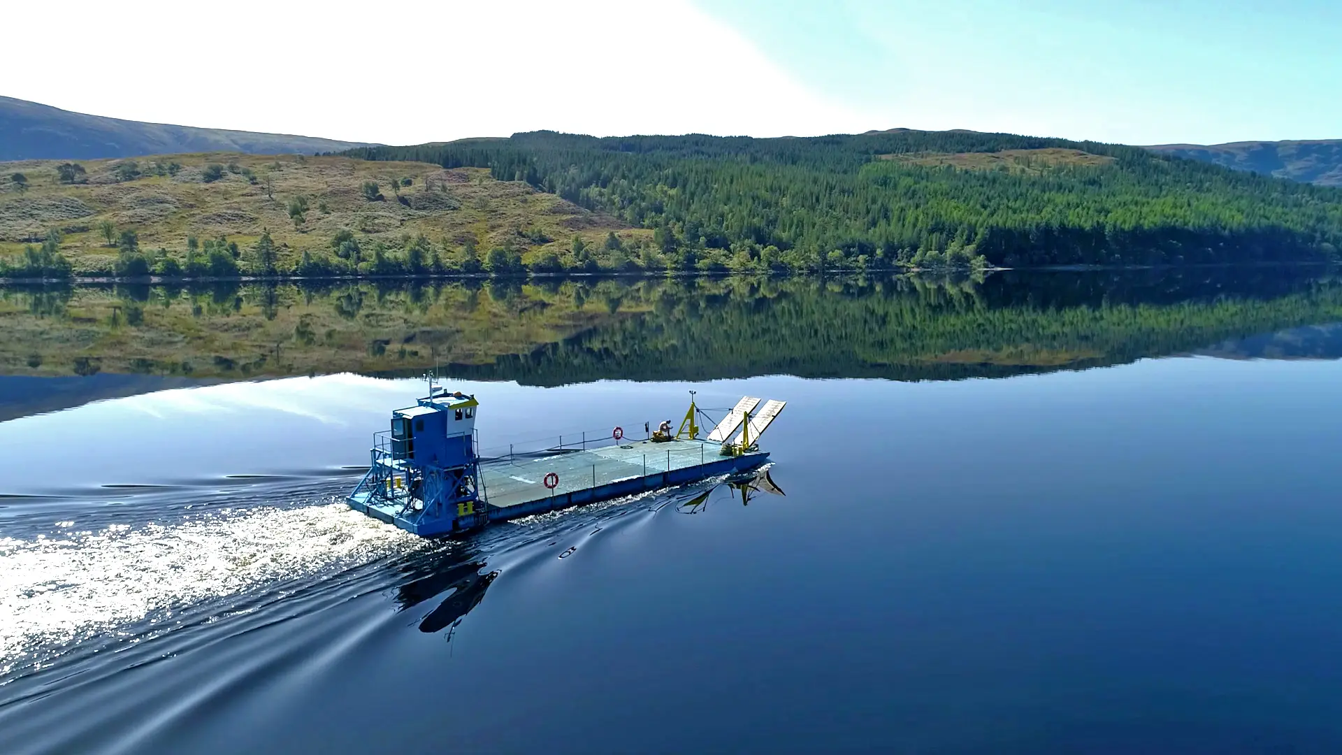 A blue boat on the water with a red and white circle on the side.
