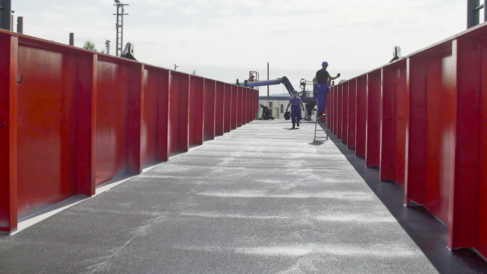 A man is standing on a red bridge.