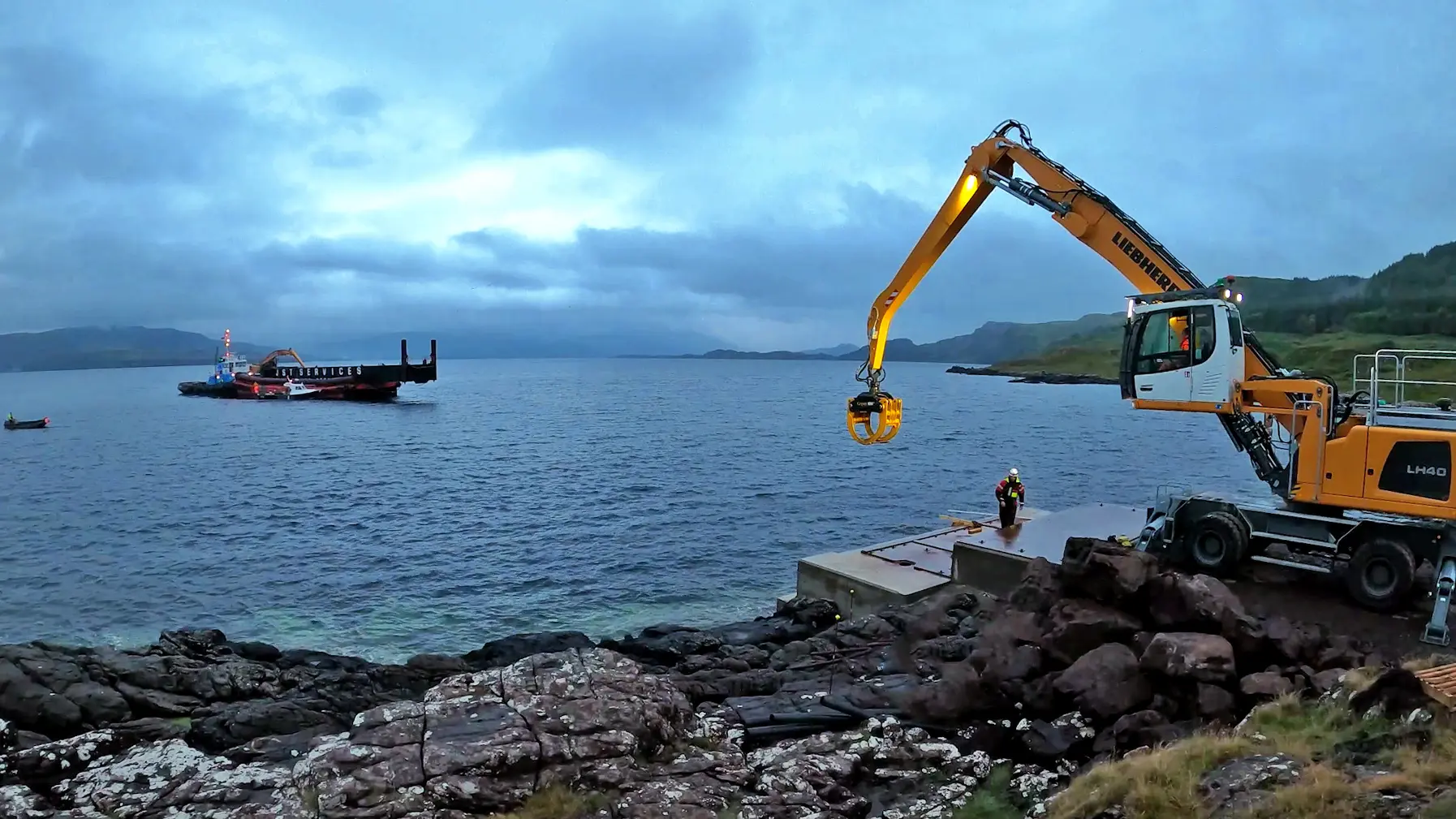 A yellow crane is lifting a man out of the water.