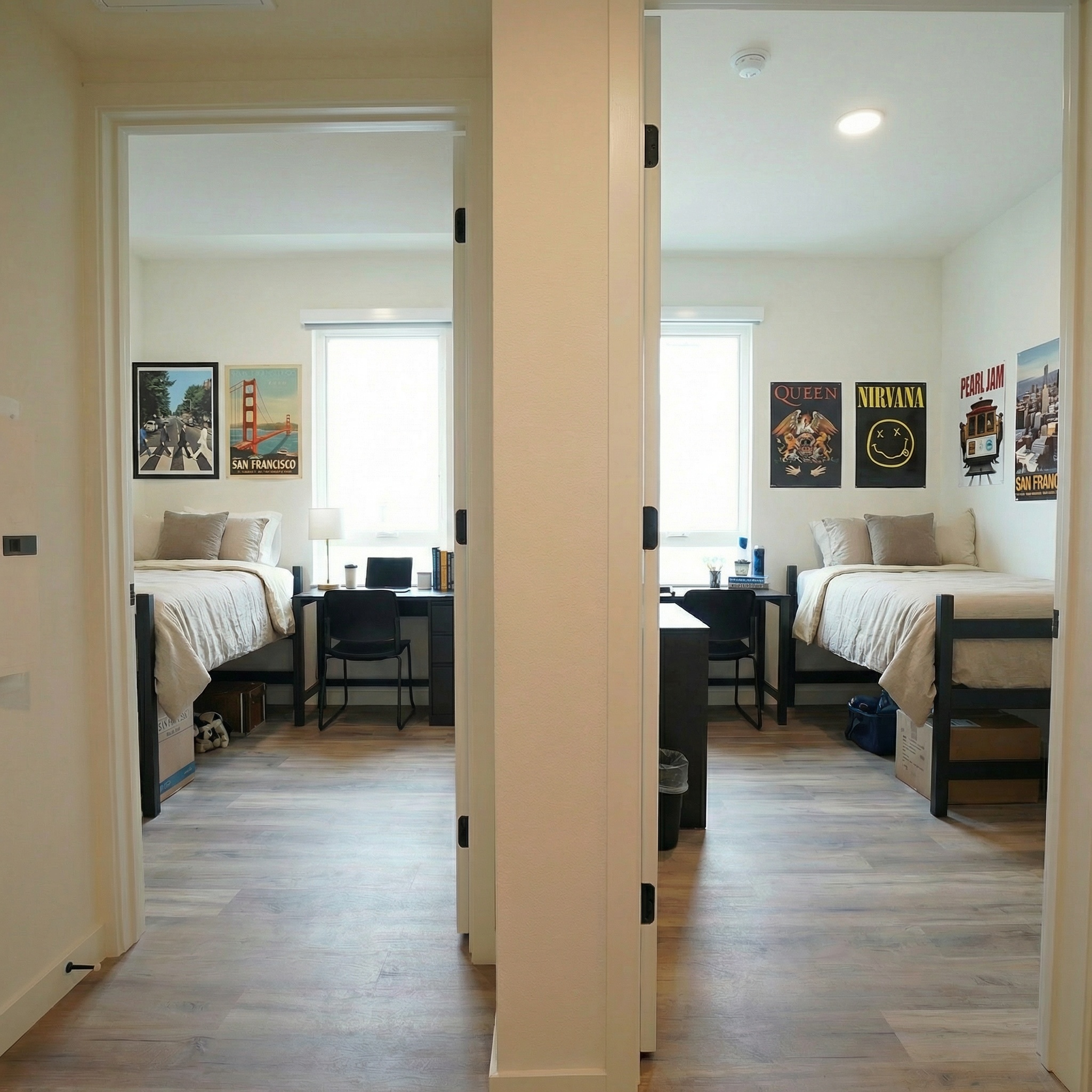 View from hallway at two bedrooms fully furnished featuring a bed, a dedicated desk area, and large windows at ArtHaus Dwight in Berkeley, CA.