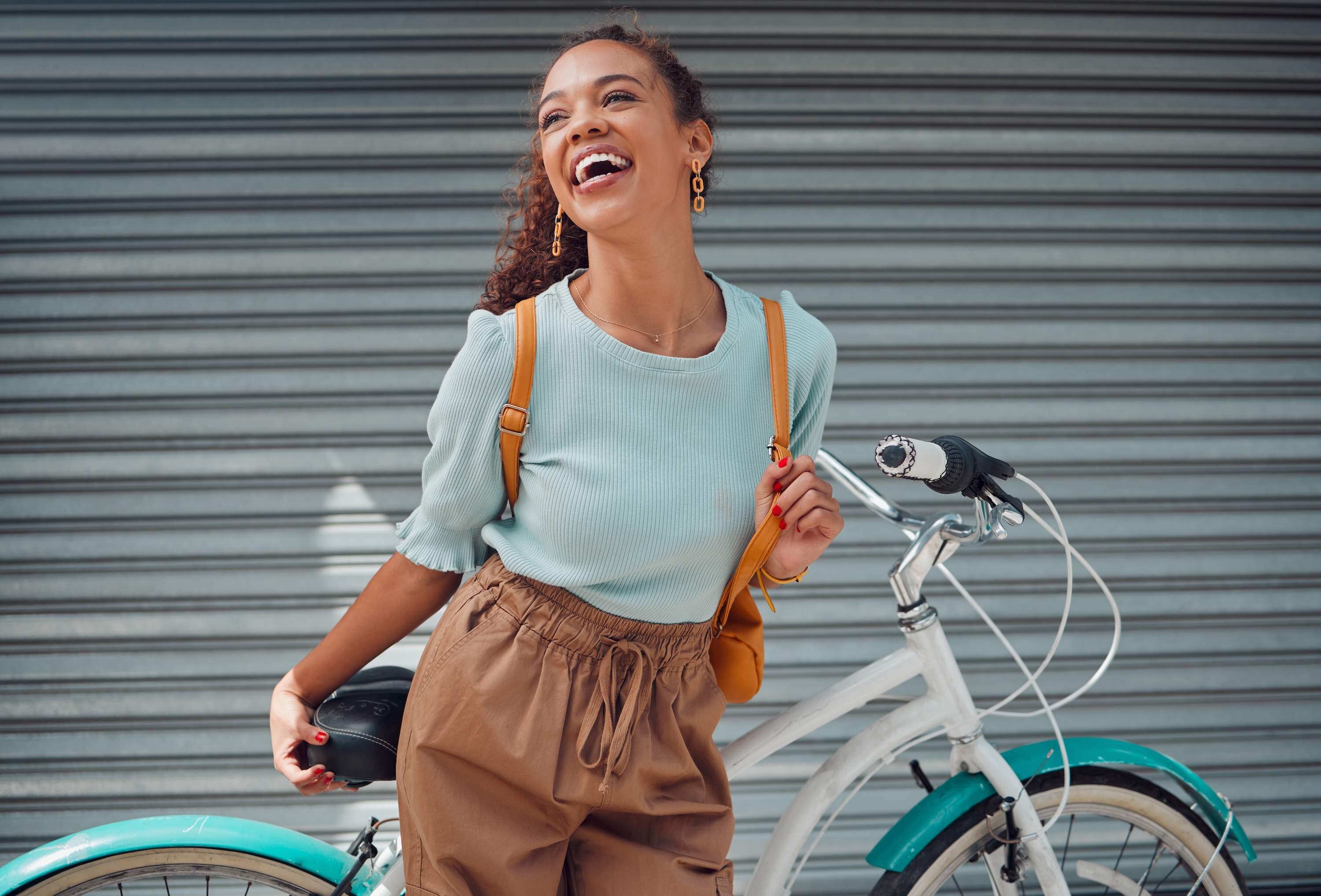 A smiling resident with a bicycle near ArtHaus Dwight apartments in Berkeley, showcasing the community's bike-friendly urban lifestyle near campus.