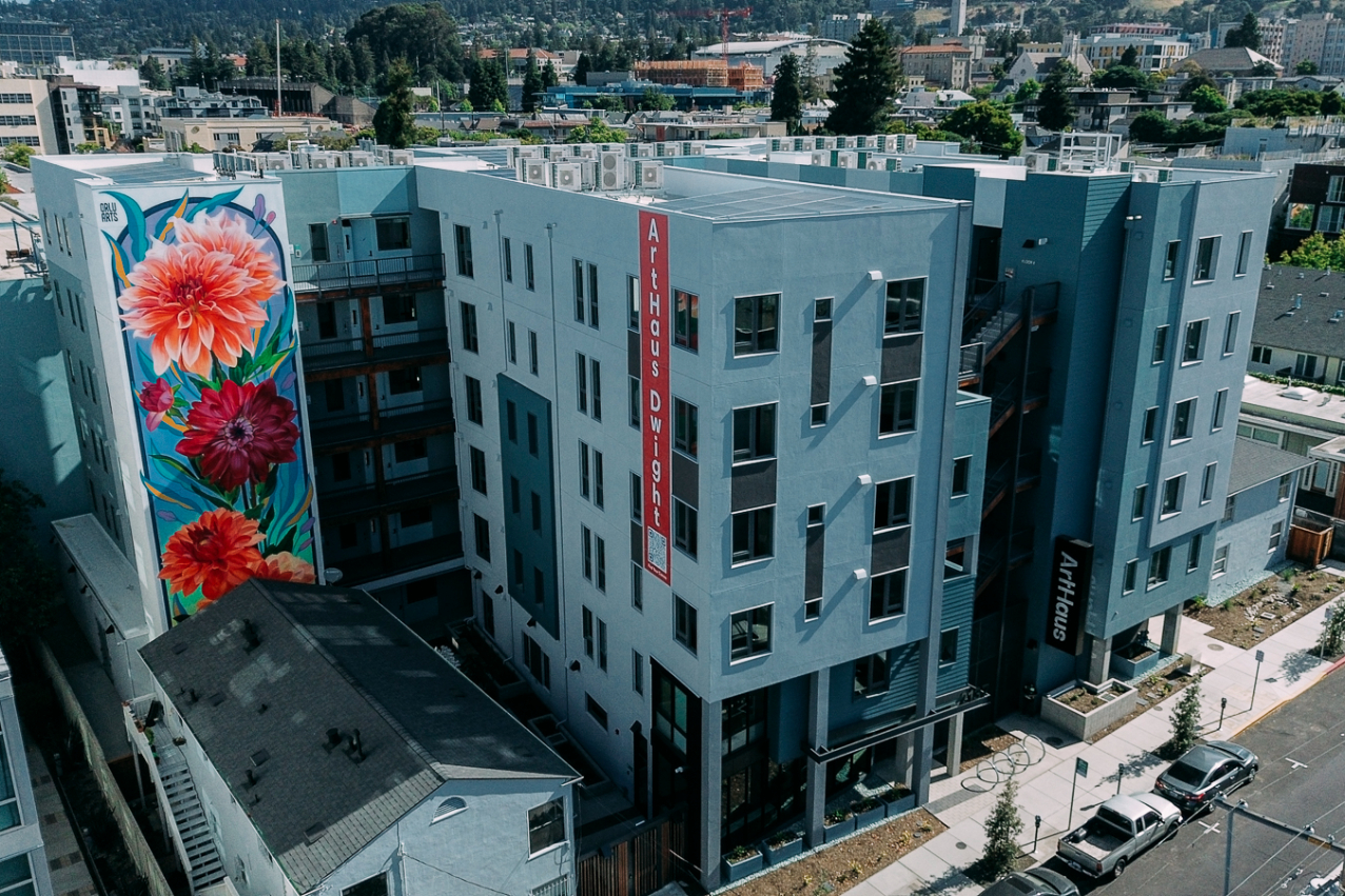 The exterior of ArtHaus Dwight, a multi-story modern apartment building with beige, white and blue sidings