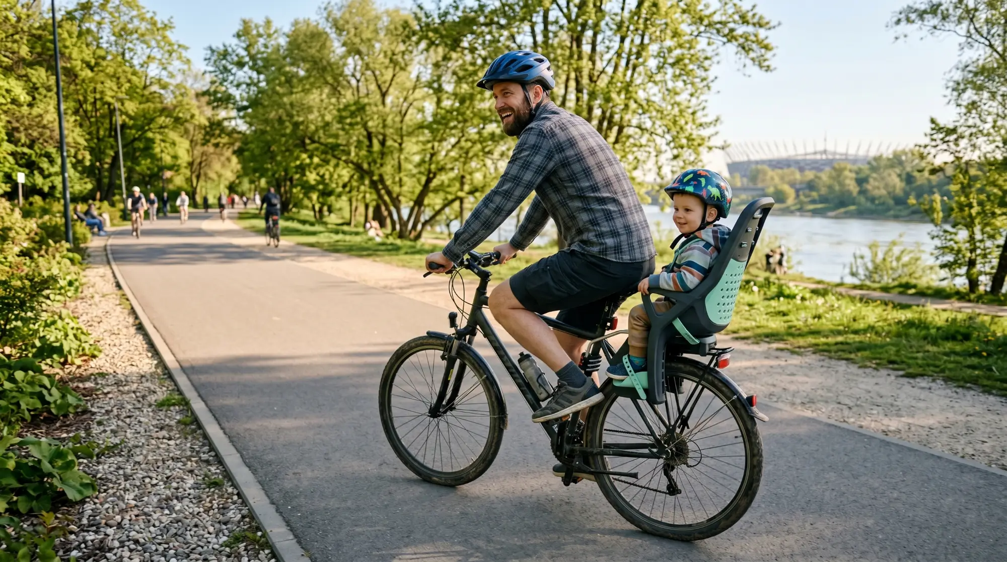 Fotelik rowerowy Hamax Caress zamontowany na ramie roweru z dzieckiem w kasku