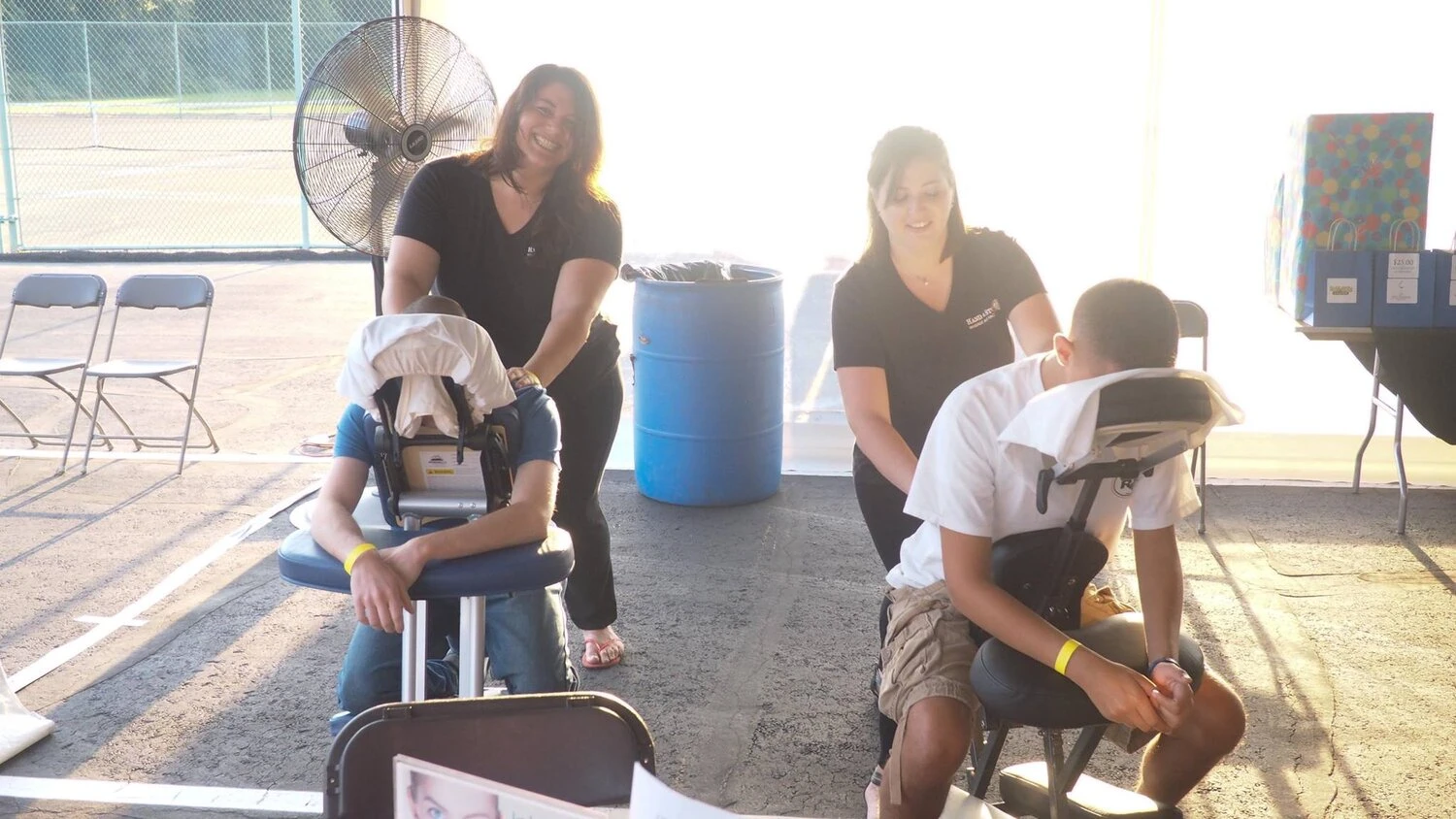 two people sitting is massage chairs receiving a back massage