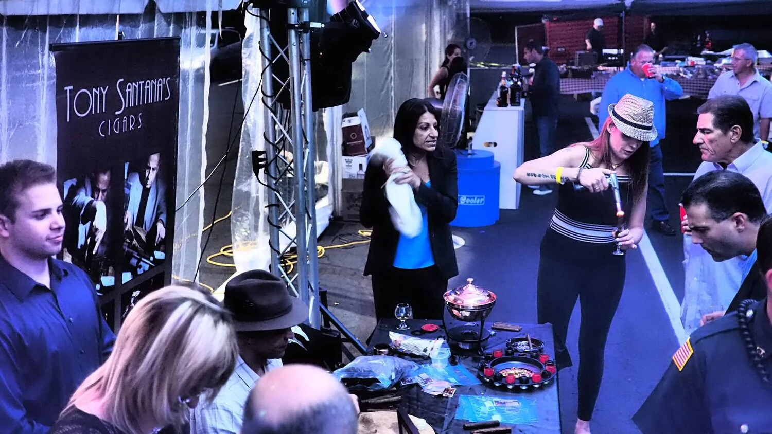 a small crowd listens to woman speak about cigars