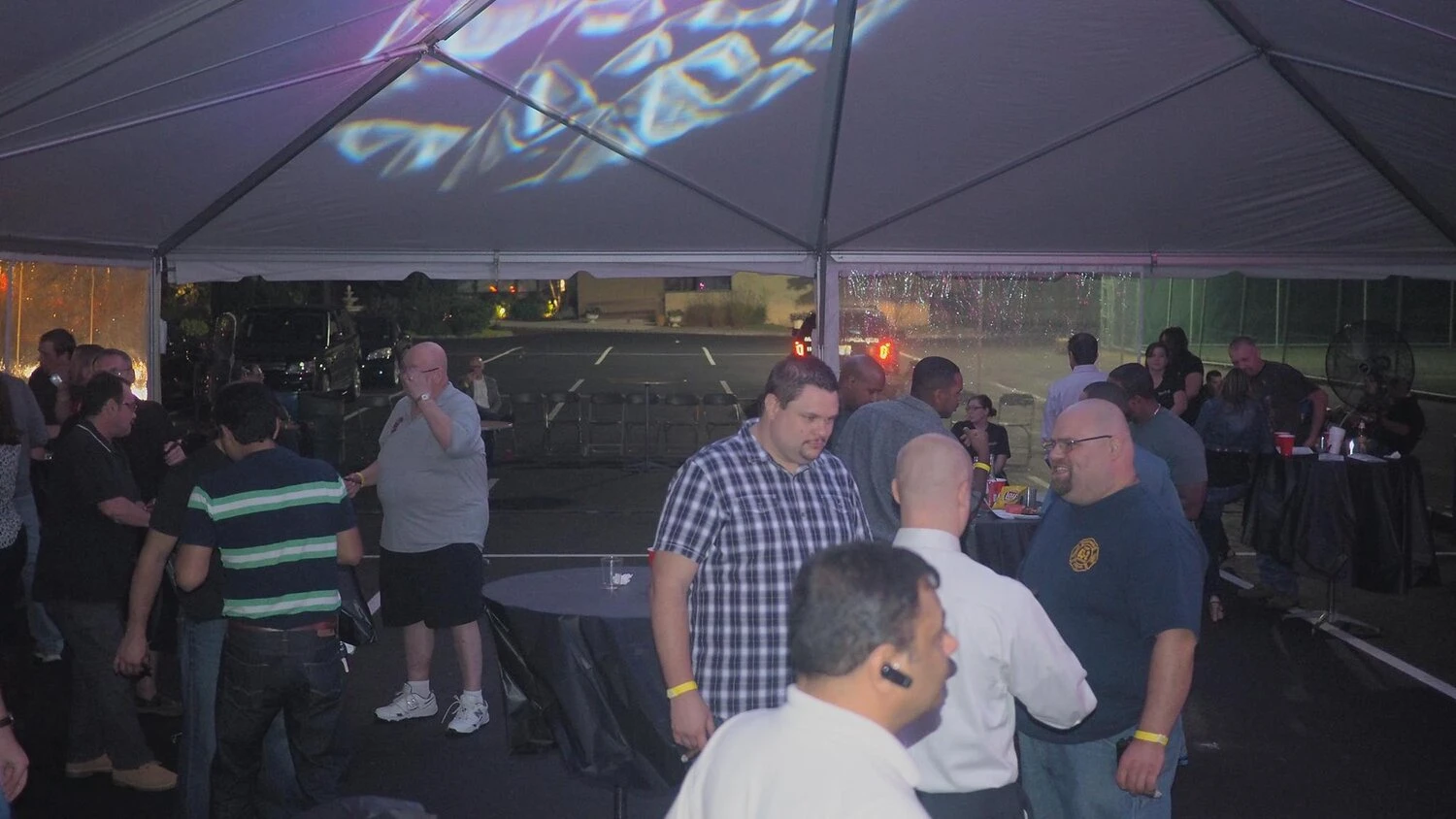 people under a tent mingling and conversing