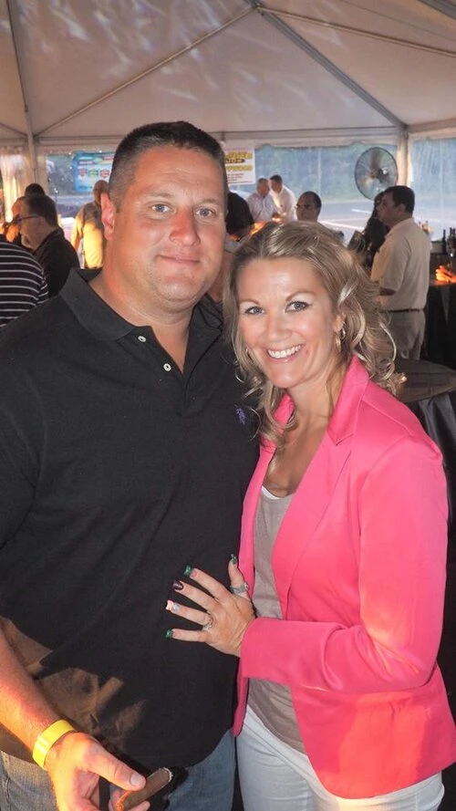 two people standing together one holding a cigar