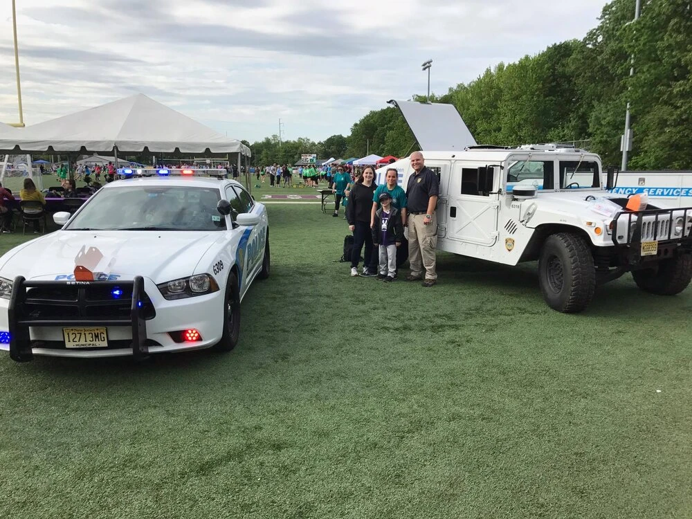 a family taking a photo by two police vehicles