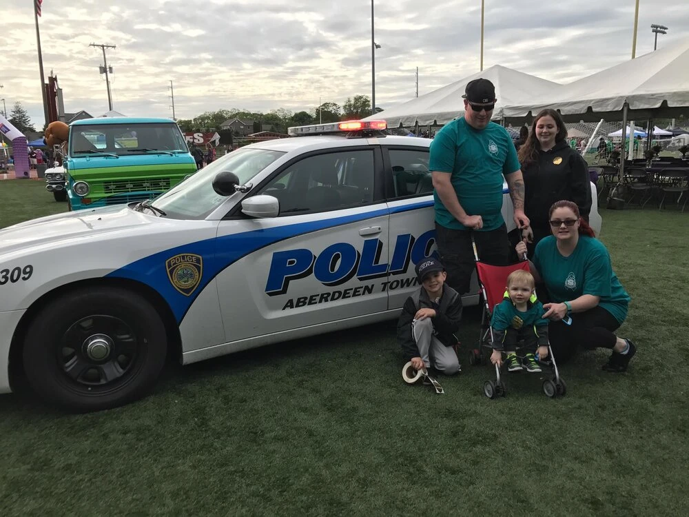 a family in front of a  police car