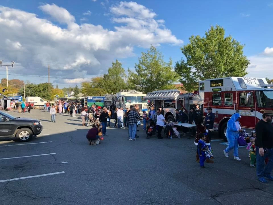 a large crowd explores various food trucks