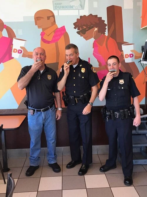 three officers take a taking. a bit of their donuts