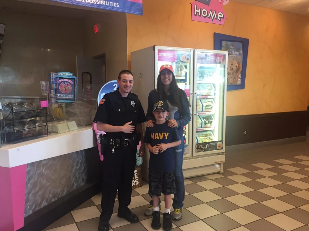 a woman and child take a photo with police officer