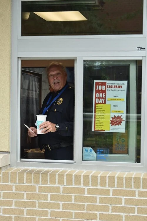 a police officer stands in the drive thru window